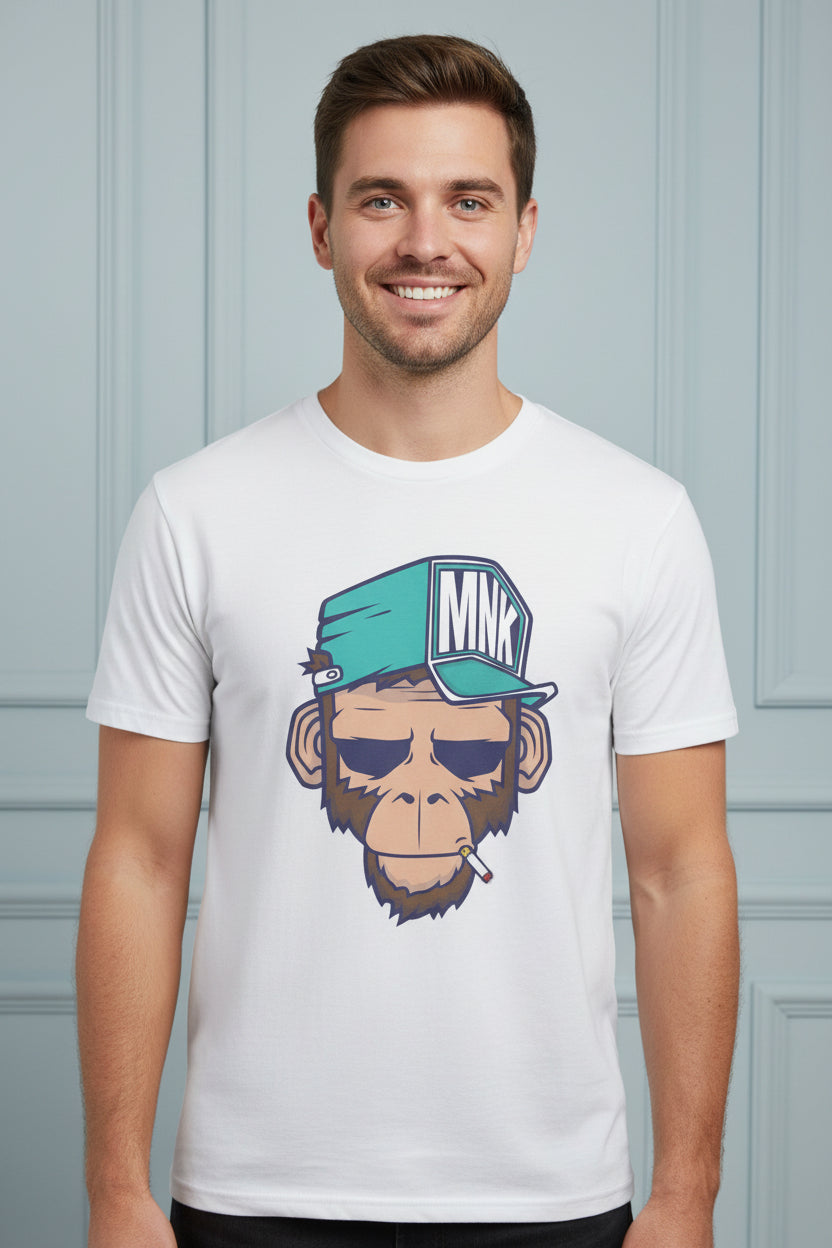 A white short-sleeve crewneck t-shirt featuring a cartoon graphic of a monkey wearing a teal cap with 'MNK' on it and smoking a cigarette. The t-shirt is displayed on a white background with decorative teal and navy blue circles behind it.