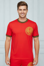 Person wearing a red sports outfit with gold accents on a white background